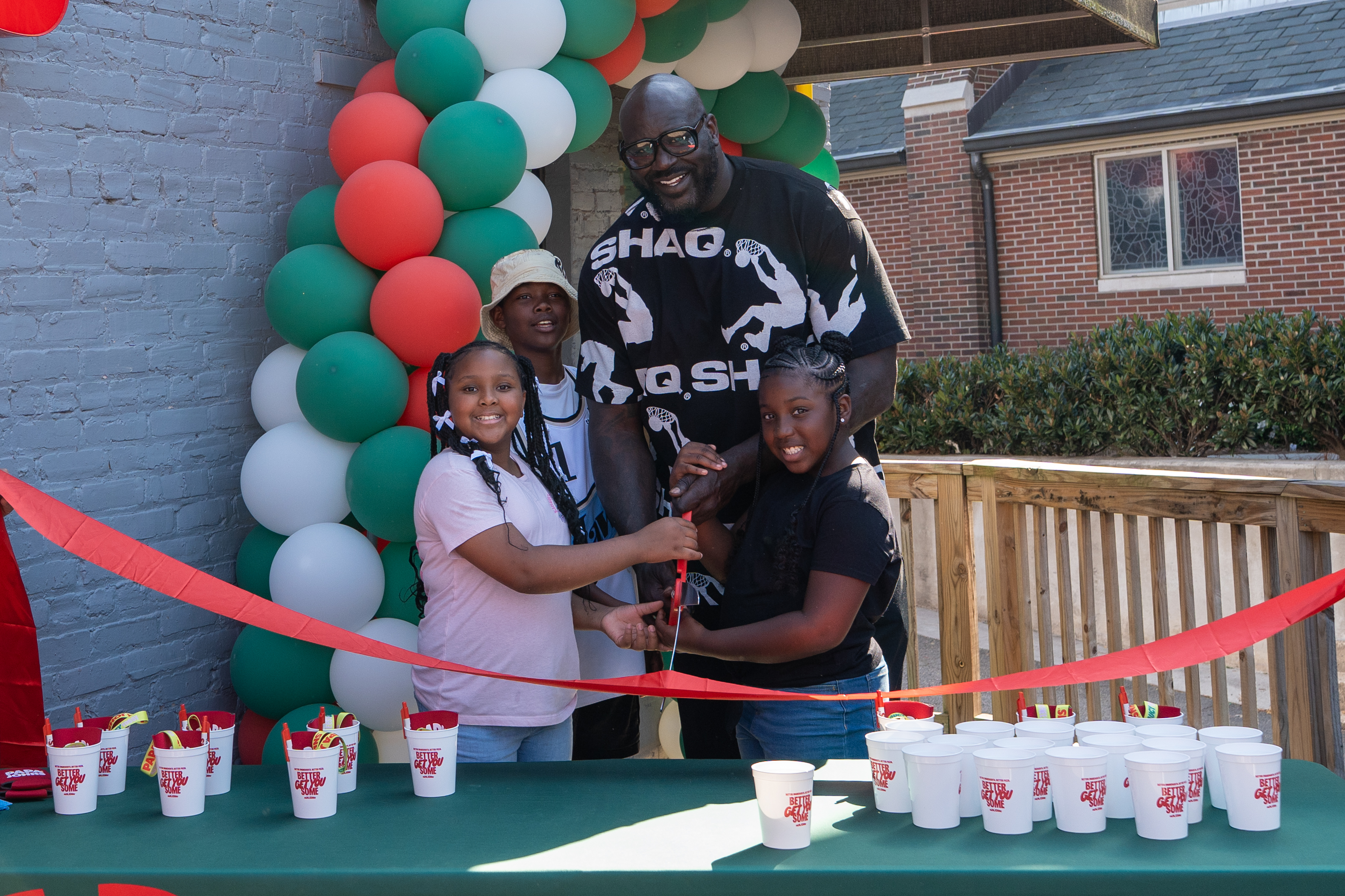 Shaq and local youths cut the ribbon at new Papa Johns restaurant