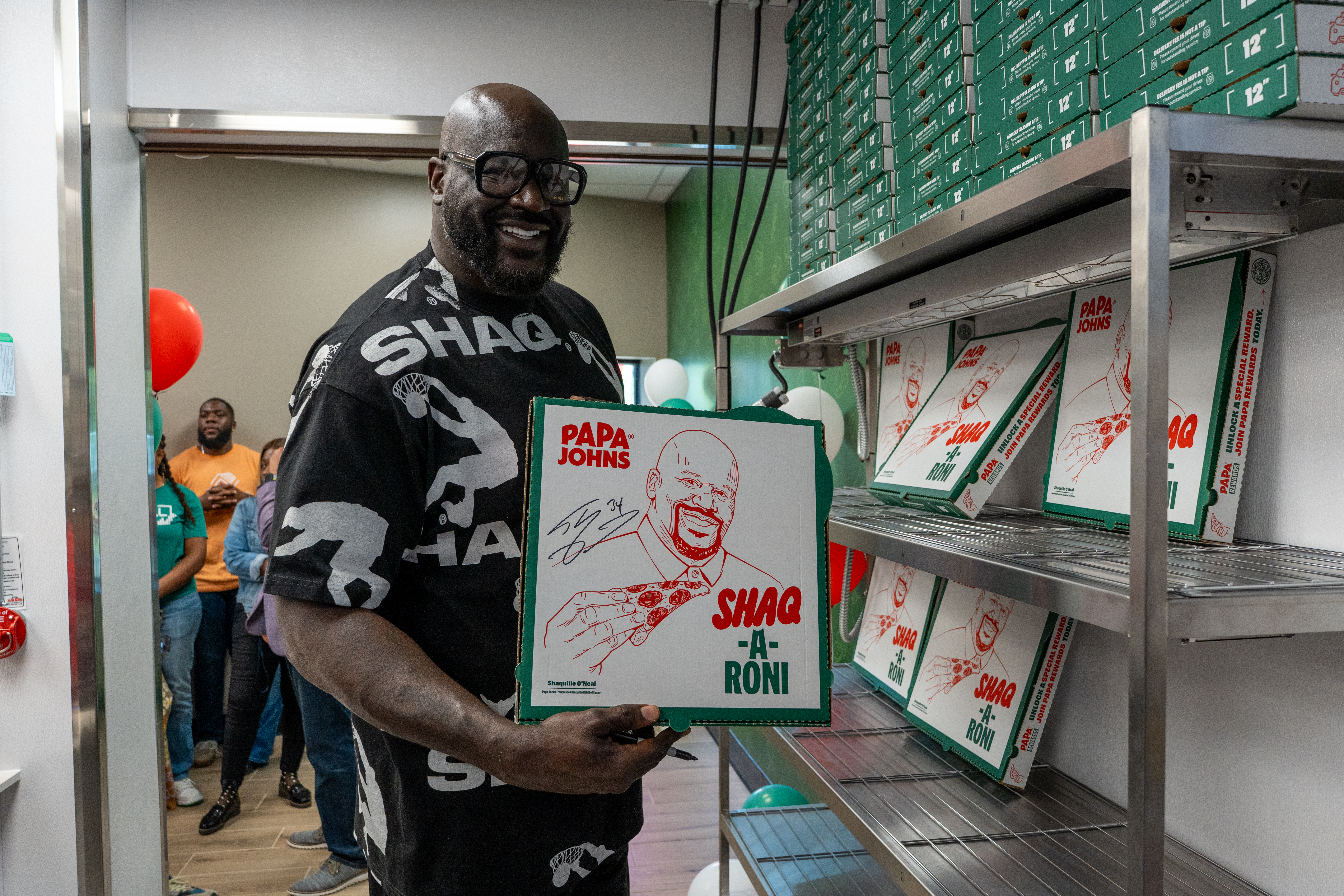 Shaq signing pizza boxes at Papa Johns
