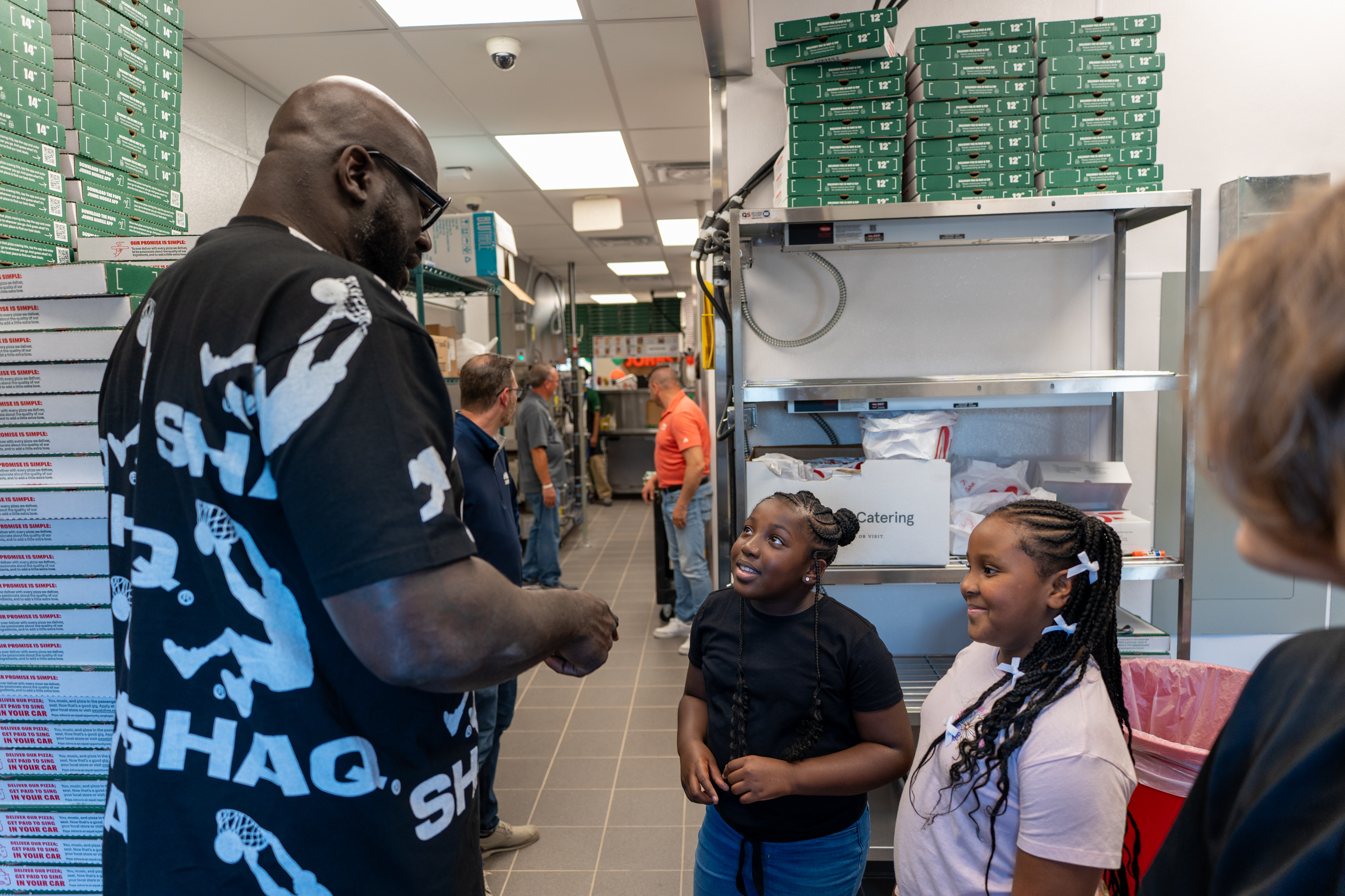 Shaq and kids inside Papa Johns restaurant