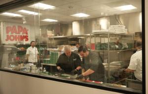People making pizzas inside the Papa Johns test kitchen