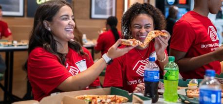 A group of students enjoying pizza.