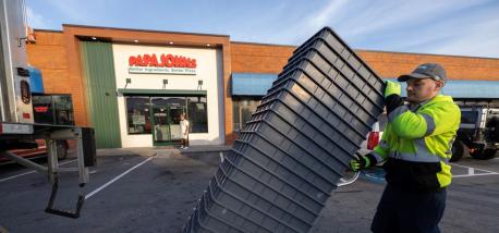A man unloading trays outside a Papa Johns restaurant