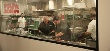 People making pizzas inside the Papa Johns test kitchen